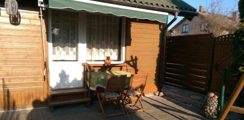 a patio with a table and a chair in front of a house at Apartamentai Alyvu 14 Palanga in Palanga