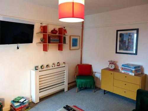 Cette chambre dispose d'une télévision, d'un bureau et d'une chaise. dans l'établissement Inalong - Quirky property with sea views above an Ale House, à Mumbles