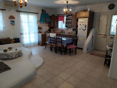 una cucina e un soggiorno con tavolo e frigorifero di Traditional House Marivilla a Mastichárion