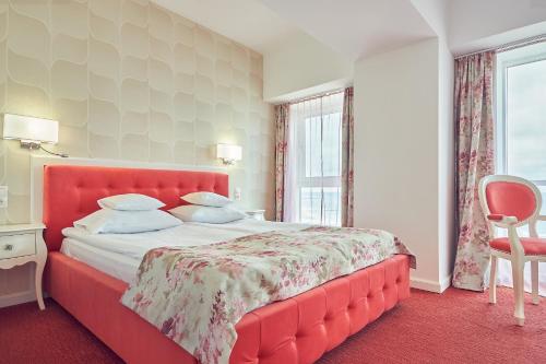 a bedroom with a large bed with a red headboard at Continental Forum Constanta in Constanţa