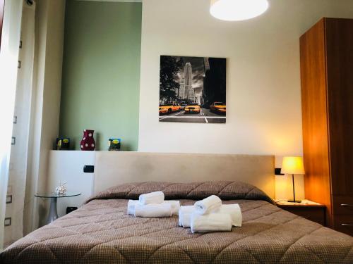 1 dormitorio con 1 cama y 2 toallas blancas en Residence Oasi Di Monza, en Monza