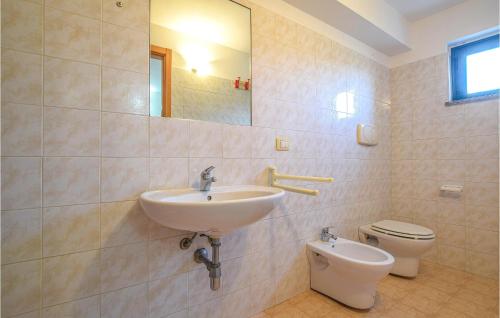 La salle de bains est pourvue d'un lavabo et de toilettes. dans l'établissement Beautiful Apartment In Portigliola With House A Mountain View, à Portigliola
