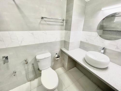 La salle de bains blanche est pourvue de toilettes et d'un lavabo. dans l'établissement Marine Holiday, à Hulhumalé
