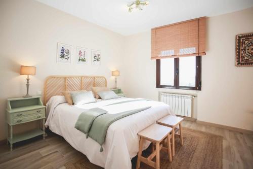 a bedroom with a large white bed and a window at Casa Rural Sierra Oeste in Madrid