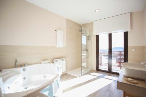 a white bathroom with a tub and a sink at Casa Rural Sierra Oeste in Madrid