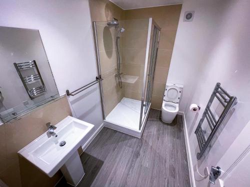 a bathroom with a shower and a sink and a toilet at Ilford Luxury Apartments in Ilford