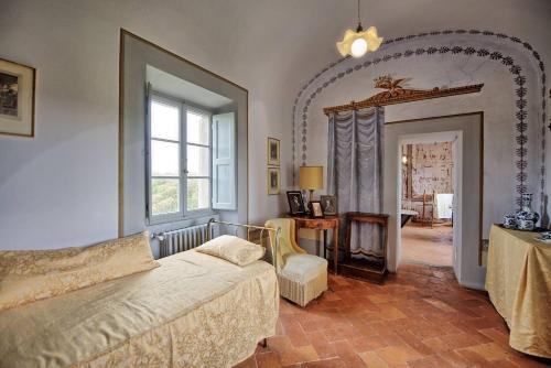 a bedroom with a bed and a table and a window at Villa Guadagni Cappelli in Arezzo