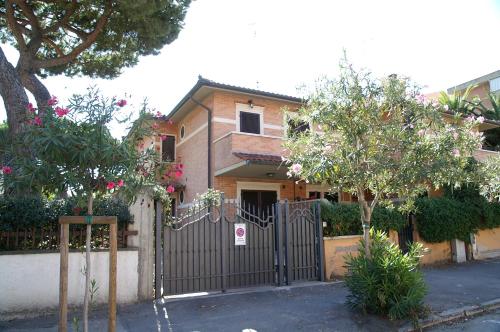 a house with a gate and trees in front of it at Ville sul Mare in Marina di Grosseto