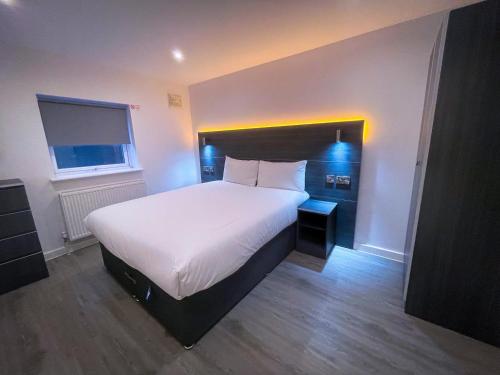 a bedroom with a large bed with a white comforter at Ilford Luxury Apartments in Ilford