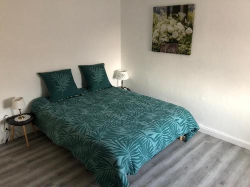 a bedroom with a bed with a green comforter at Appartement in Chateau Saint Claude an der Saone in Mantoche