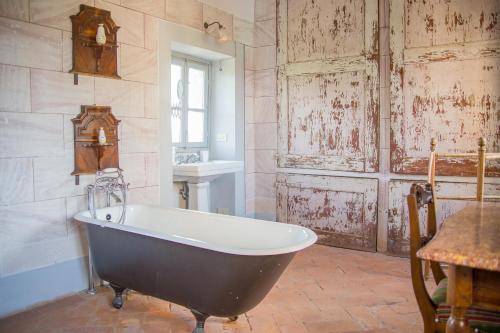 an old tub in a room with a table and a table at Villa Guadagni Cappelli in Arezzo