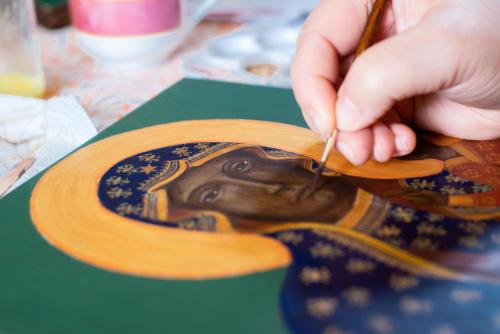 a person is cutting a picture of a painting of a president at Kurnik Polski agroturystyka in Tykocin