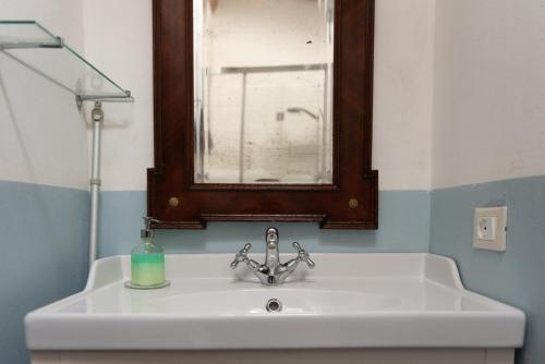 a bathroom sink with a window and a soap bottle on it at Stone House 15th Century in Vicchio