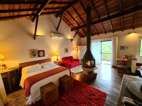 a bedroom with a large bed and a fireplace at Pousada Serra da Índia in Penedo