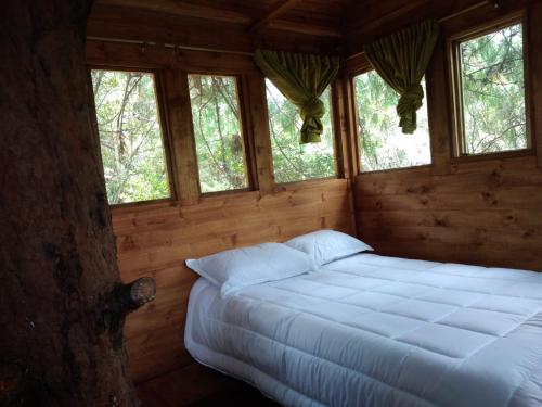 a bedroom with a bed in a log cabin at Entre Rocas y Cristales in Ráquira