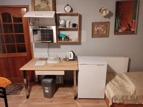 a kitchen with a desk with a refrigerator and a table at Podelniska in Porąbka