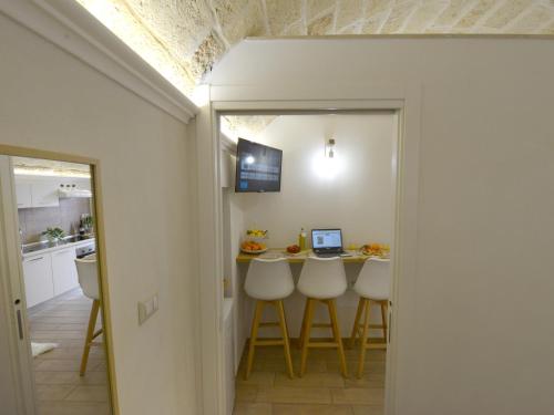 una cucina e una sala da pranzo con tavolo e computer portatile di Castrum Casa Vacanza a Mesagne