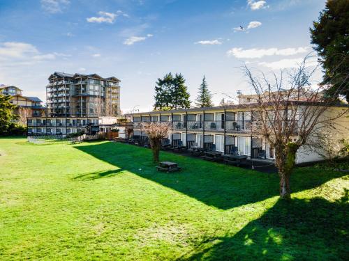 a large grassy yard in front of a building at Sea Edge Motel in Parksville