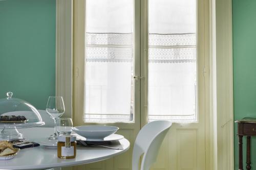 a table with two chairs and a white table with two windows at Casa Tiffany in Modica