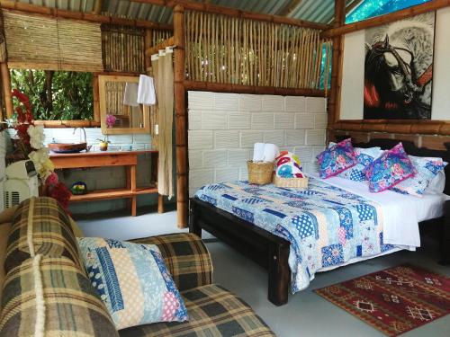ein Schlafzimmer mit einem Bett und einem Sofa in der Unterkunft Finca Ecoturistica LOS JAGUEYES in Baraya