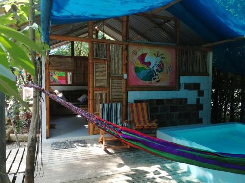 a hammock in front of a house at Finca Ecoturistica LOS JAGUEYES in Baraya