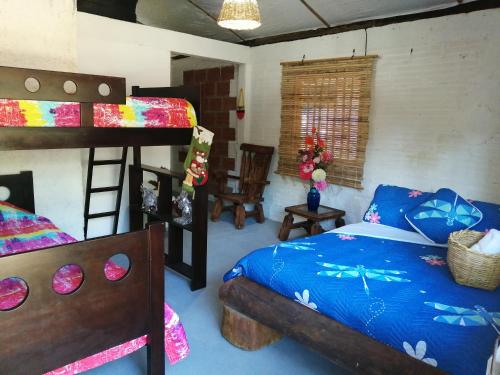 a bedroom with a bed and a bunk bed at Finca Ecoturistica LOS JAGUEYES in Baraya