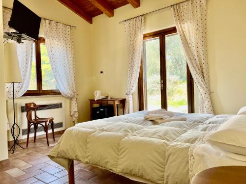 Un dormitorio con una cama grande y una ventana en Casale Terre Rosse, en Saturnia