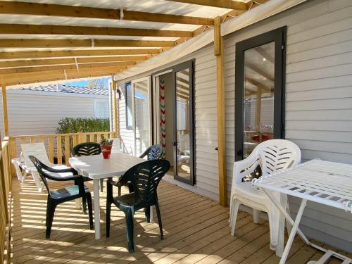 a patio with a table and chairs on a deck at Camping Pleine Mer in Vias