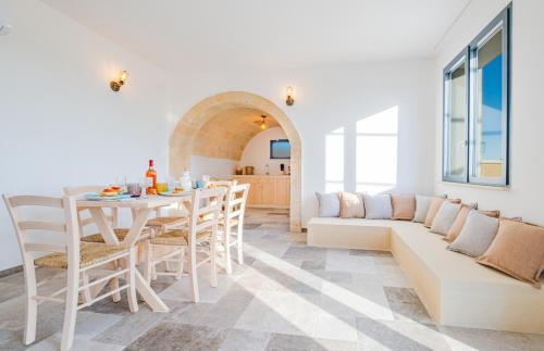 a white living room with a table and a couch at Villa Li Tratturi Luxury by HDSalento in Corsano