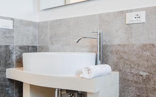 a bathroom with a white sink and a wall at Villa Li Tratturi Luxury by HDSalento in Corsano