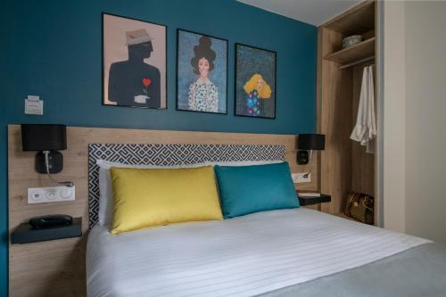 a bedroom with a bed with blue walls at Bristol Nice in Nice