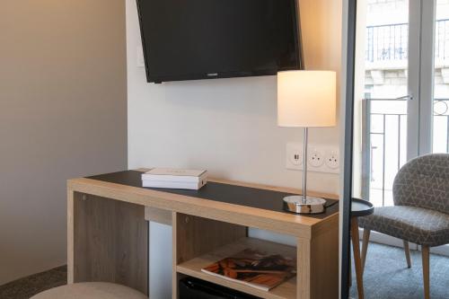 a room with a desk with a tv and a chair at Bristol Nice in Nice