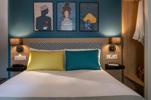 a bedroom with a bed and some pictures on the wall at Bristol Nice in Nice