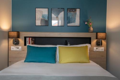 a bedroom with a bed with three pictures on the wall at Bristol Nice in Nice