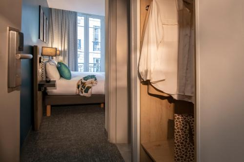 a hallway with a bed in a room with a window at Bristol Nice in Nice