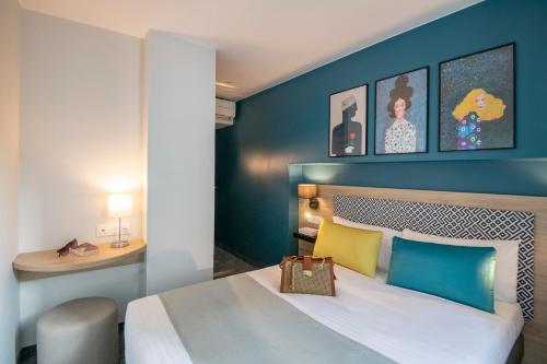 a bedroom with a bed with a blue wall at Bristol Nice in Nice