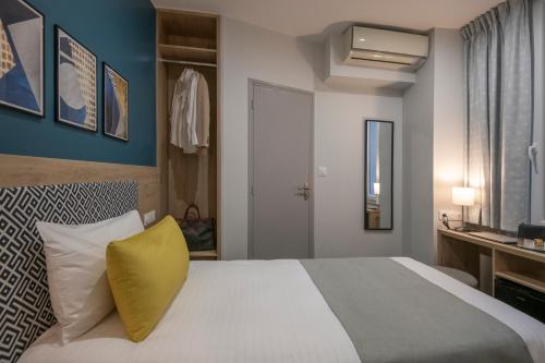 a bedroom with a large bed with a yellow pillow at Bristol Nice in Nice