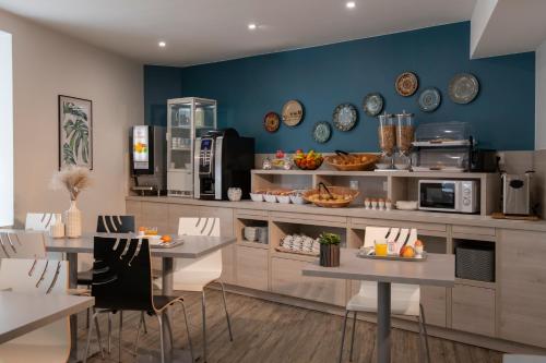 a kitchen with two tables and a counter with appliances at Bristol Nice in Nice
