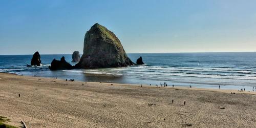 a large group of people on a beach near the ocean at Hallmark Resort in Cannon Beach in Cannon Beach