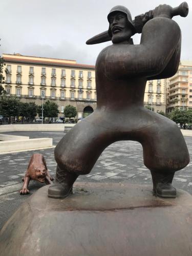 a statue of a woman with a hat on the street at International Naples in Naples