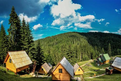 eine Gruppe von Hütten in den Bergen mit Bäumen in der Unterkunft Eko Katun Bungalows Jelovica in Berane