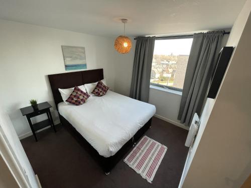 a small bedroom with a bed and a window at Stratford Luxury Apartments in London