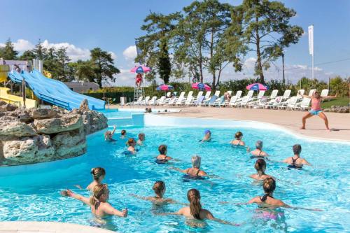 - un groupe de personnes dans la piscine d'un complexe dans l'établissement Bungalow cosy en campagne à Onzain avec piscine partagée, à Onzain