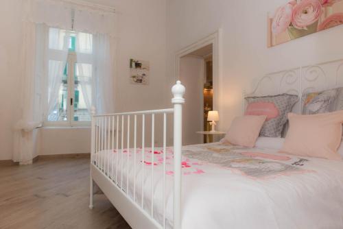 1 dormitorio con cama blanca y cuna blanca en Maison la Mitra - Dimore Partenopee en Nápoles