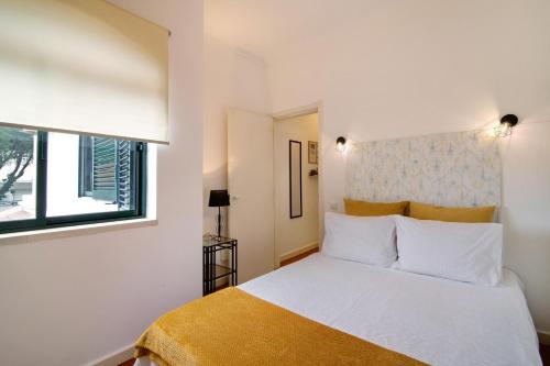 a bedroom with a white bed and a window at Apartamento Medusa by Sunnyway in Olhos de Água