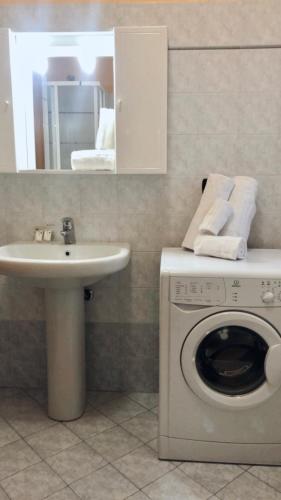 a bathroom with a washing machine and a sink at Residence Oasi Di Monza in Monza