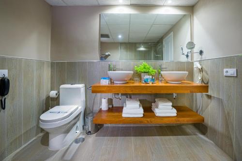 a bathroom with a sink and a toilet and a mirror at LANZAROTE PRIME SPORTS by Vitalclass Lanzarote Resort in Costa Teguise