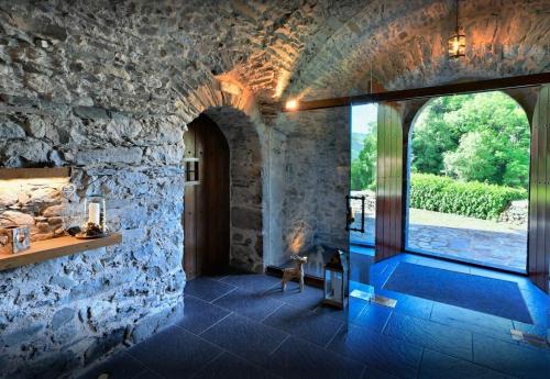 a stone house with a fireplace and a stone wall at Mas Can Buixat in Setcases