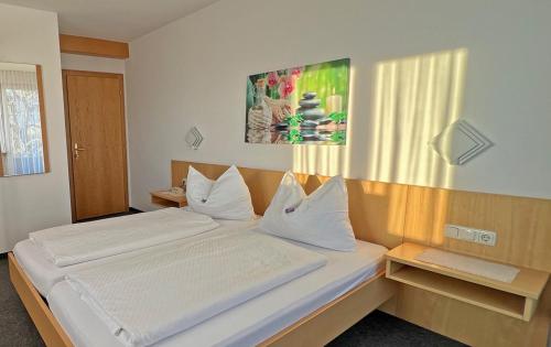 a bedroom with a large bed with white sheets at Hotel-Pension Sternen in Klaus