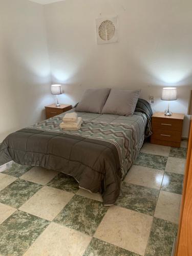 1 dormitorio con 1 cama con 2 mesitas de noche y 2 lámparas en El Rincon Del Duende, en Vejer de la Frontera
